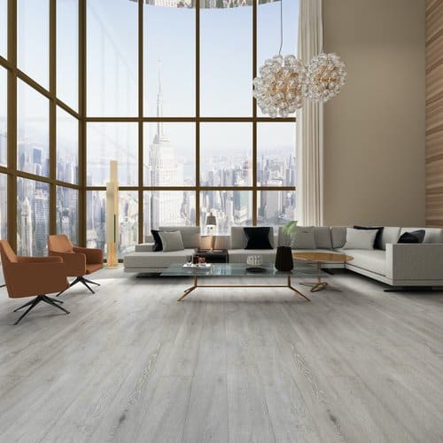 Light wood-look plank floor in a bright living room with tall windows